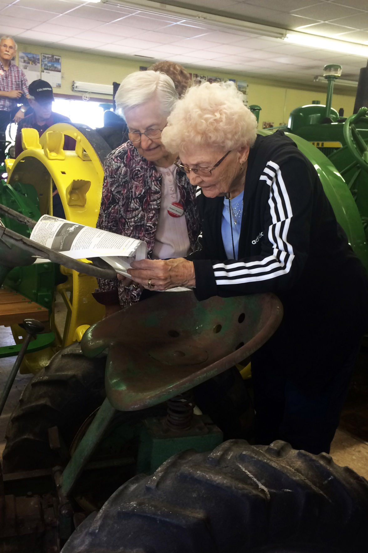 019 Joann Bower and Doris Djernes examined the small hand-crafted tractor at the John Deere Museum in Neligh.JPG